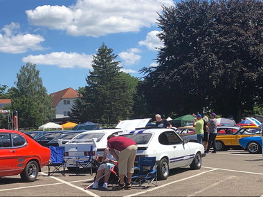 Offene Motorhauben mit gepflegtem Motorraum locken Zuschauer an
Open bonnets with well-maintained engine compartments attract spectators
Les capots ouverts avec un compartiment moteur bien entretenu attirent les spectateurs